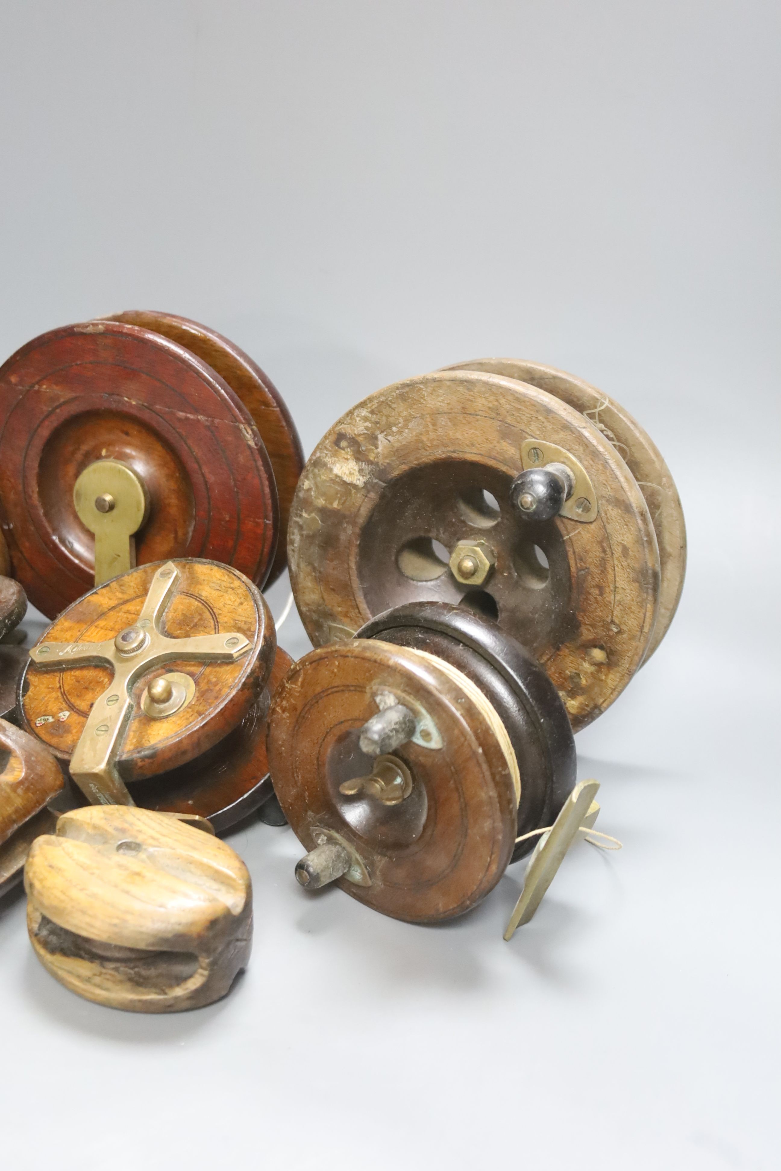 A collection of wooden fishing reels, largest diameter 16cm